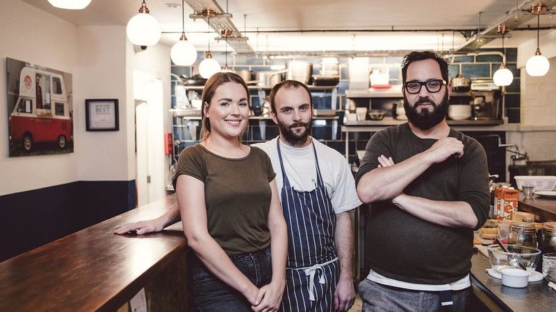 Female, male chef and male smiling in a restaurant